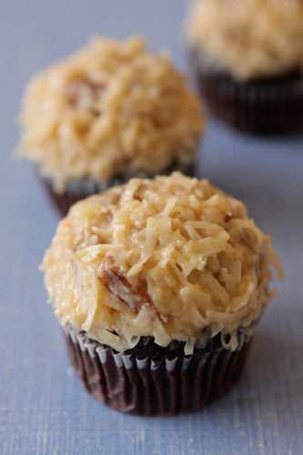 A photo of chocolate cupcakes topped with coconut pecan frosting.