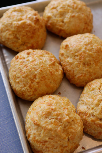 Golden brown cheddar biscuits on a baking sheet
