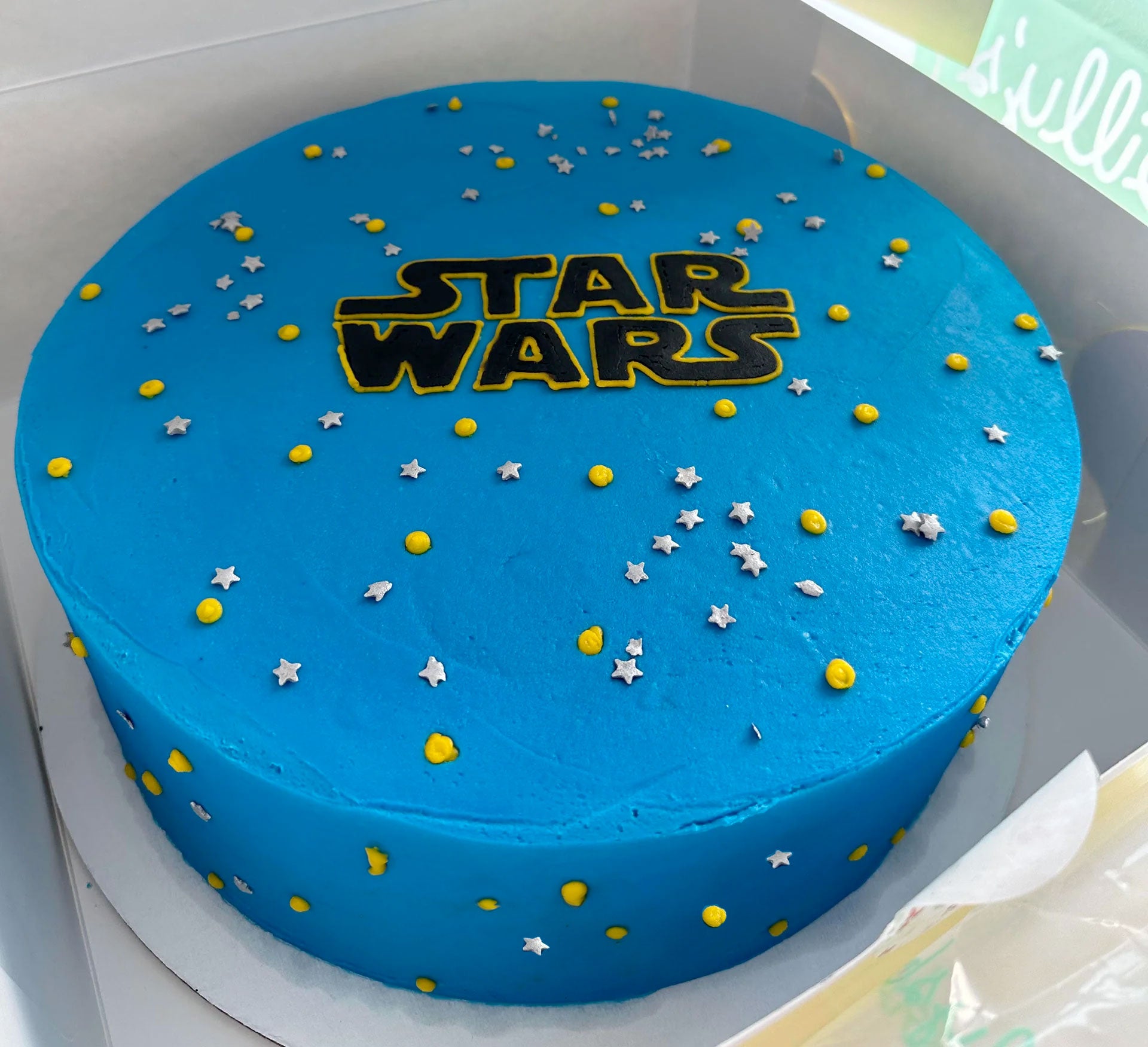 Star Wars themed birthday cake with blue frosting and yellow and white star sprinkles.